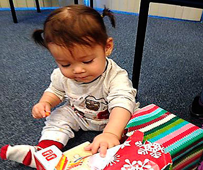 A child enjoying a present at Make it Take it
